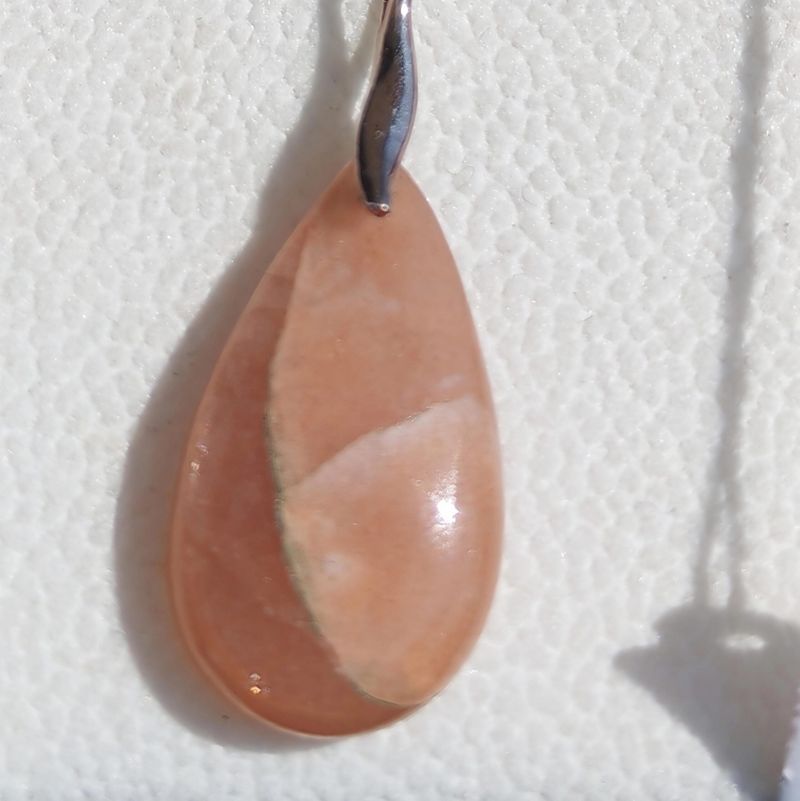 Pendentif goutte Pierre de Soleil scintillante en gros plan.