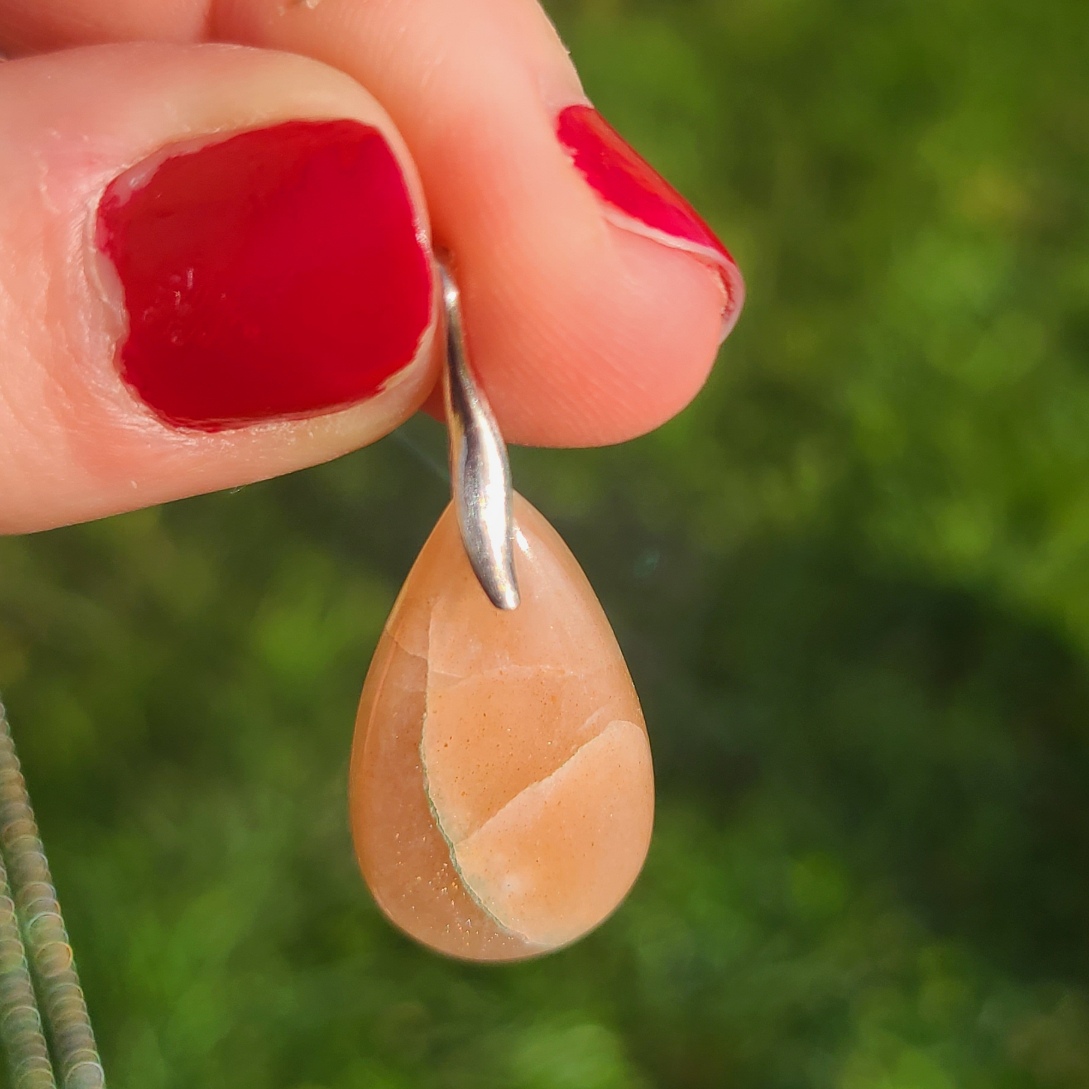 pendentif en pierre de soleil, présentation taille réelle lumière naturelle