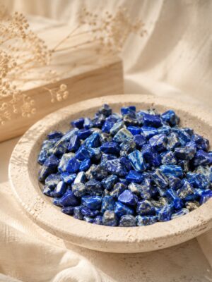 Chips de lapis-lazuli présentés dans une coupelle en pierre dans une ambiance douce et lumineuse