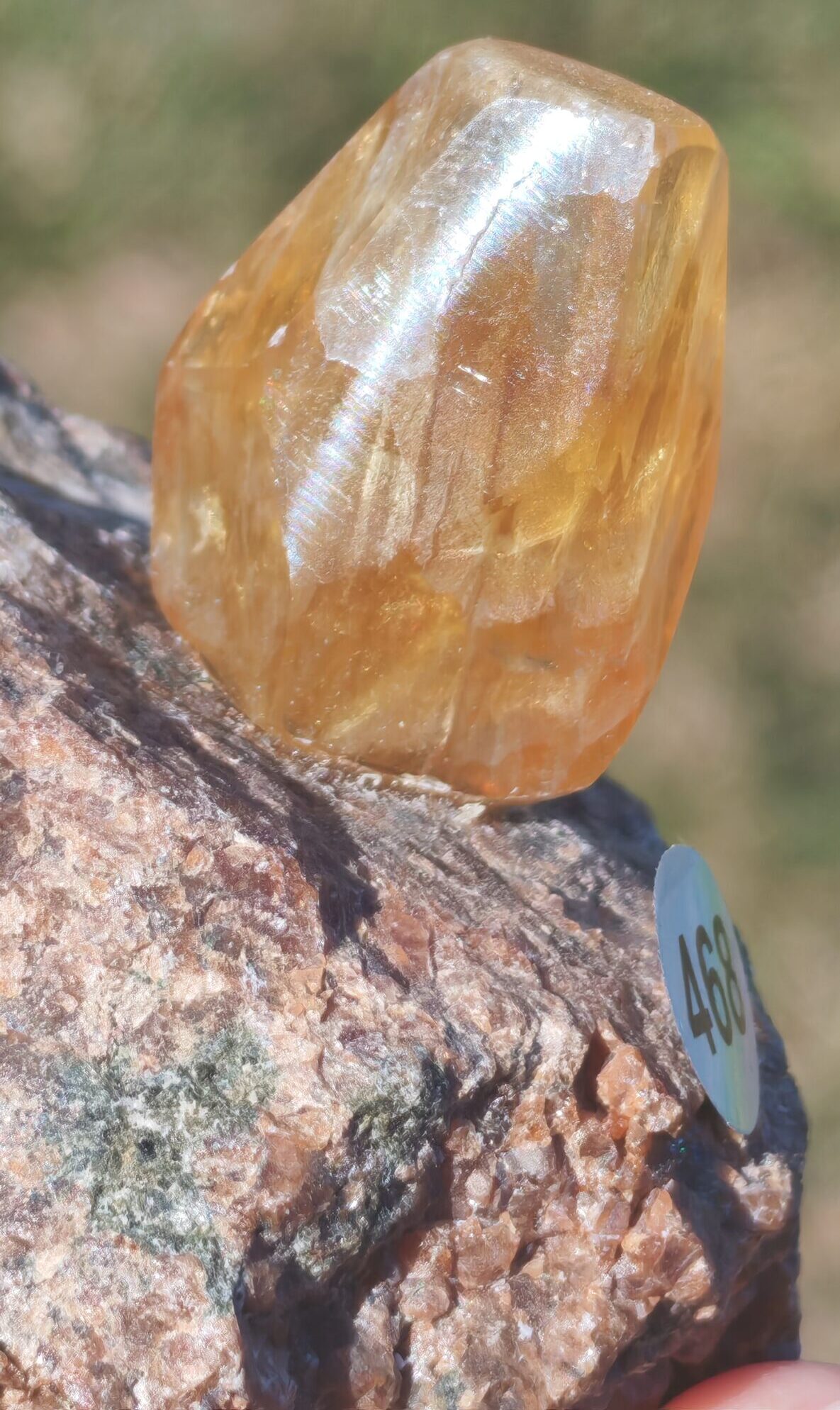 Gros plan de la face repolie de la fluorite jaune doré avec un reflet lumineux à la surface